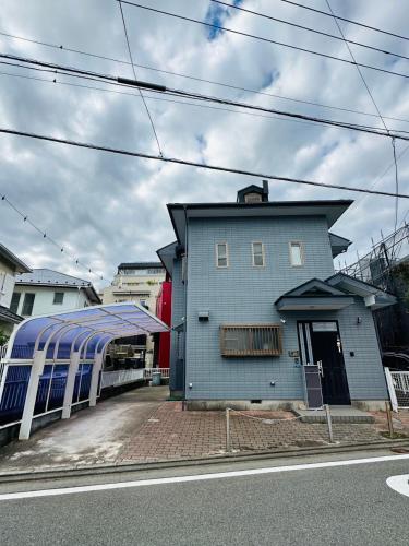 a blue building next to a train station at Kugenuma Kaigan Beachside House#ENOSHIMA#Aquarium in Fujisawa