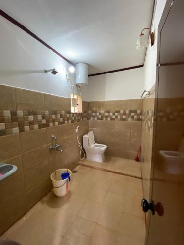 une salle de bains avec toilettes et lavabo dans l'établissement Coorg jungle Cottage, à Kushalanagar