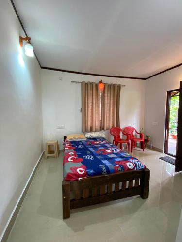 une chambre avec un lit, une table et des chaises dans l'établissement Coorg jungle Cottage, à Kushalanagar