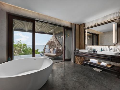 un bagno con una grande vasca e una grande finestra di 珠海凤凰湾悦榕庄 a Zhuhai