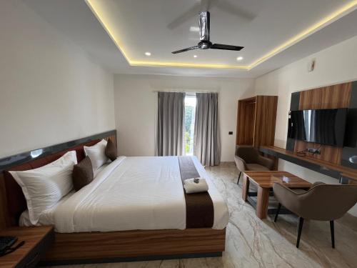 インドールにあるHotel Veronicaのベッド、机、テレビのある寝室