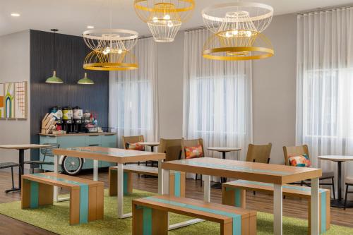 a dining room with tables and chairs and chandeliers at Spark by Hilton Toronto Mississauga in Mississauga