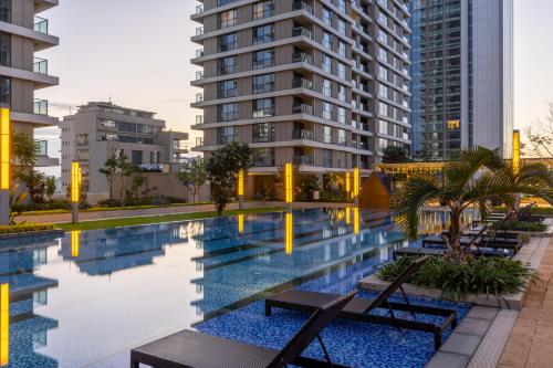 ein Schwimmbad vor einigen hohen Gebäuden in der Unterkunft Pan Pacific Serviced Suites Nairobi in Nairobi