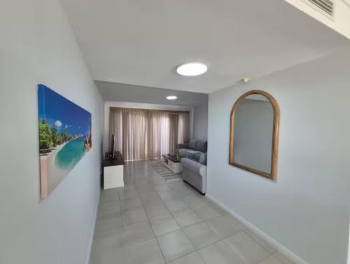 un soggiorno con un divano e uno specchio di Serenity by the Sea a Mandurah