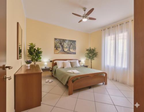 a bedroom with a bed and a ceiling fan at Casa Conca Azzurra in Costarainera