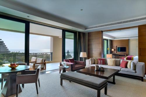 a living room with a couch and a table at Raffles Hainan Clear Water Bay in Sanya
