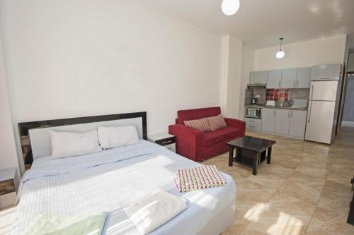 a bedroom with a large bed and a red chair at Guestroom in Malindi