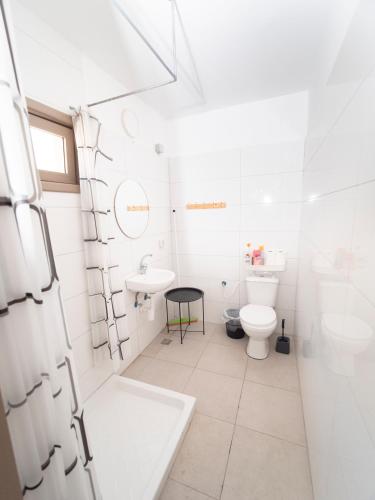 a white bathroom with a toilet and a sink at כפר הצוללים in Eilat