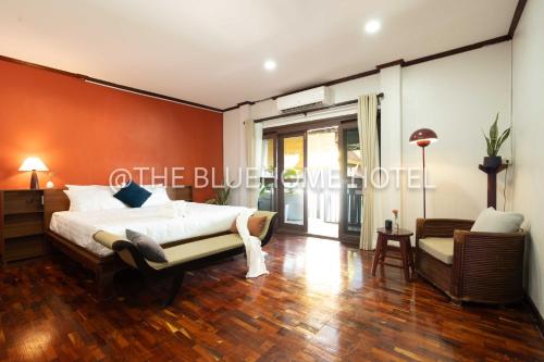 a bedroom with a bed with an orange wall at BlueHome in Vientiane