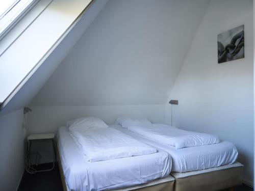 zwei weiße Betten in einem Zimmer mit Treppe in der Unterkunft Skip Wellness De Luxe with sauna in Earnewâld