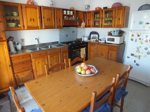 a kitchen with a wooden table with a bowl of fruit on it at Villa Dafne mare Fondi Sperlonga in Fondi