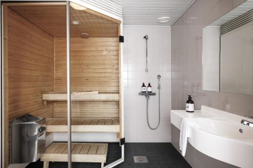une salle de bains avec sauna, lavabo et baignoire dans l'établissement Ski Resort & Hotel Pikku-Syöte, à Syöte