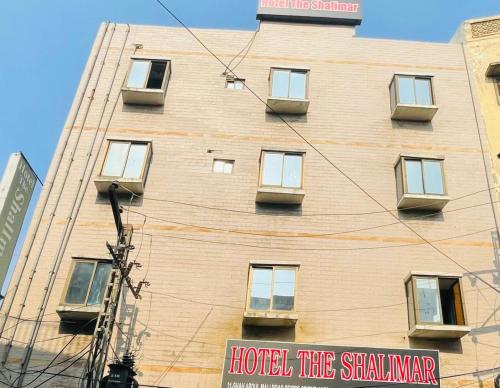 un edificio alto con ventanas y un cartel en él en Hotel The Shalimar, en Lahore