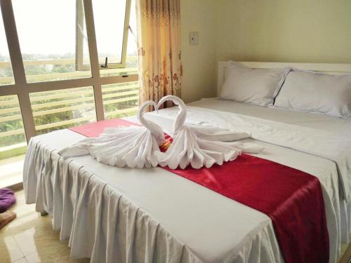 two white swans are sitting on a bed at Khách sạn Vàng Anh in Kiên Giáp Ha