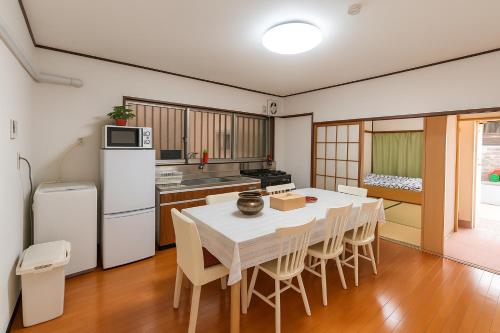 a kitchen with a table and chairs in a room at Nippori Osaka Nishi-Tengachaya Guesthouse西天下茶屋アパートメント in Osaka