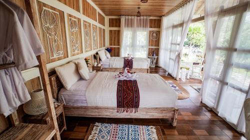 a bedroom with two beds in a room with windows at The River Island Sidemen in Sidemen