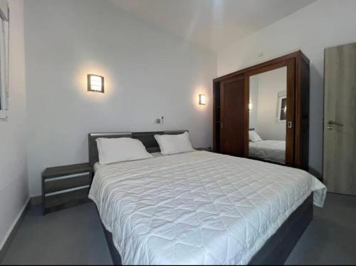 Un dormitorio con una cama grande y un espejo. en MC Home, en Yaoundé