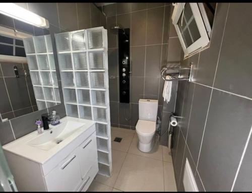 Un baño con un lavabo blanco y un inodoro. en MC Home, en Yaoundé