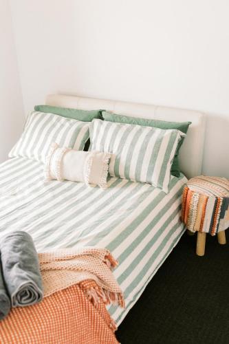 a bed with striped pillows on it in a room at Kings at Tower Hill in Illowa