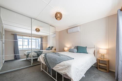 a bedroom with two beds and a large mirror at Ocean Moore - Uninterrupted Ocean Views in Guilderton