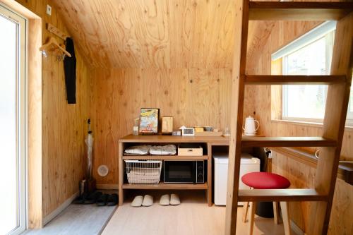 a small room with a microwave and a bunk bed at HOTEL BOTH in Shari