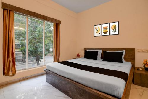 Un dormitorio con una cama grande y una ventana grande. en Super Collection O Biswa Bangla Convention Centre Kolkata Formerly Atithya Inn, en New Town