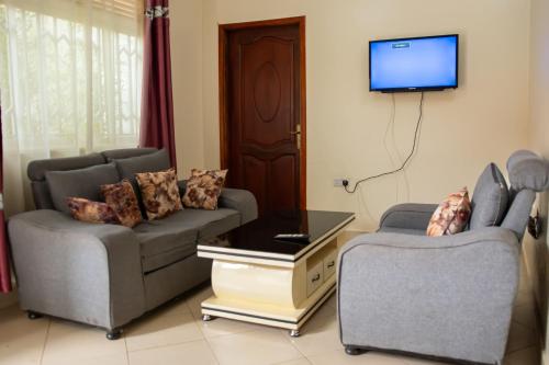 a living room with two couches and a tv at Go Culture Africa in Entebbe