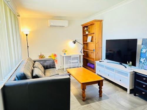 a living room with a couch and a flat screen tv at Midvale Cozy House in Bellevue