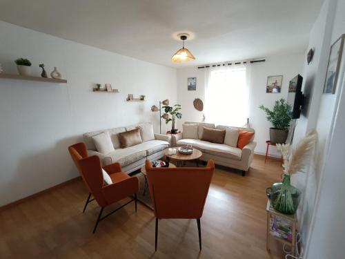 ein Wohnzimmer mit Sofa und Tisch in der Unterkunft La grande maison berrichonne in Aigurande