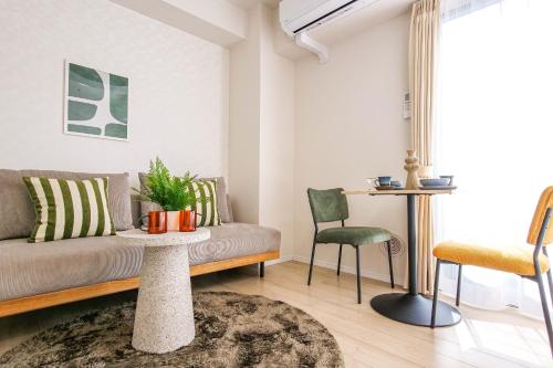 a living room with a couch and a table and chairs at Mr Kintaro Hotel Kinshicho in Tokyo