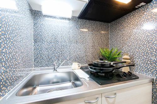 cocina con fregadero y fogones con olla en Mr Kintaro Hotel Kinshicho, en Tokio