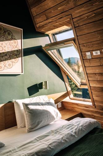 a bedroom with a bed and a large window at УЛІС Ворохта in Vorokhta