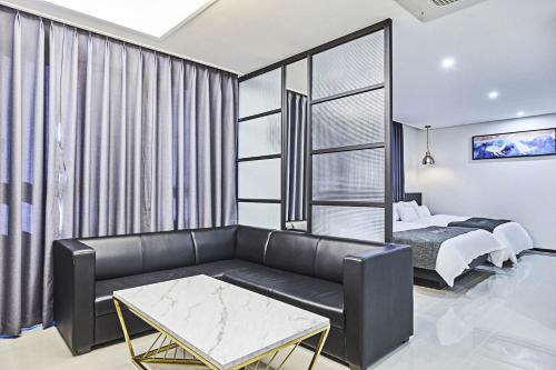 a living room with a couch and a bed at Hoteld Benikea in Osan