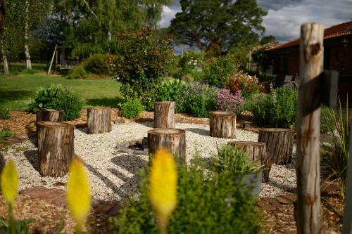 a garden with wooden stumps in a yard at Tuscan Farmhouse in Launching Place