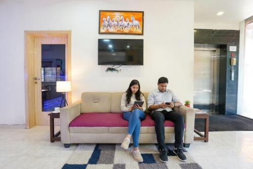 un hombre y una mujer sentados en un sofá en FabHotel Regent Inn - Nr SkyWalk Bridge, en Pune
