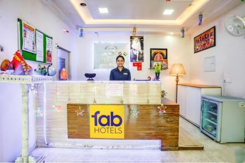 Una mujer parada detrás de un mostrador en una habitación. en FabHotel Regent Inn - Nr SkyWalk Bridge, en Pune