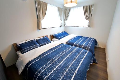 due letti in una piccola stanza con due finestre di Villa de Mui nago Kaula D a Nago