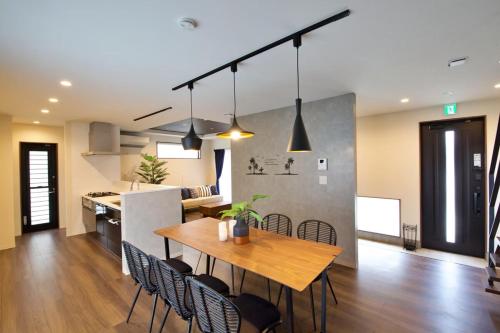 a kitchen and dining room with a wooden table and chairs at Villa de Mui nago Kaula D in Nago