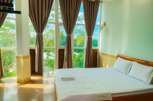a bed in a room with a large window at Nhật Linh Homestay in Hue