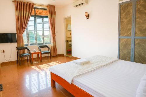 a bedroom with a bed and a table and chairs at Nhật Linh Homestay in Hue
