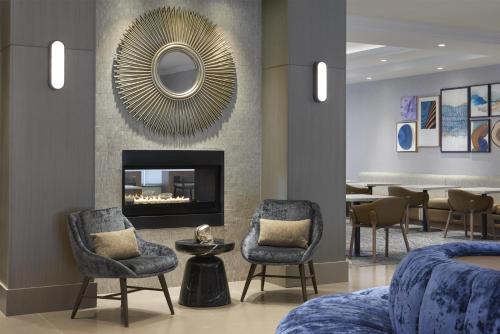 a lobby with chairs and a fireplace and a table at Homewood Suites by Hilton Toronto Vaughan in Vaughan