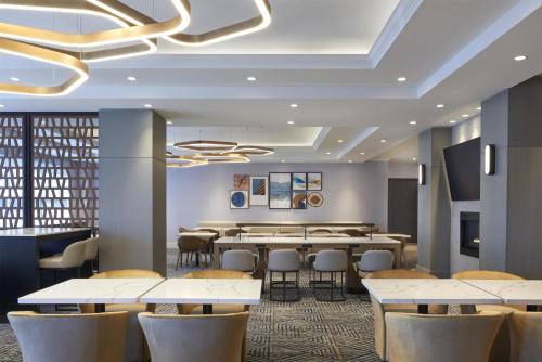 uma sala de jantar com mesas e cadeiras em Homewood Suites by Hilton Toronto Vaughan em Vaughan