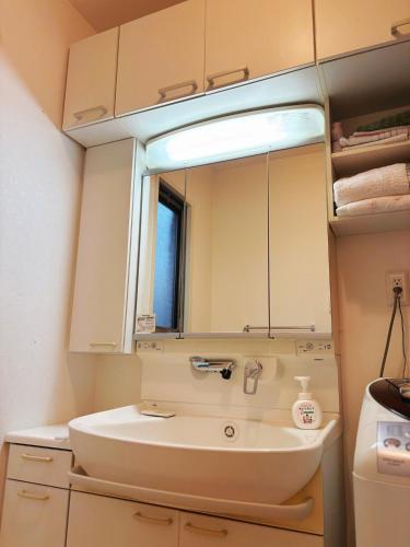 a bathroom with a sink and a mirror at Aki House居住型民泊小岩駅まで送迎あり in Tokyo