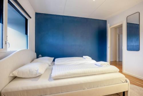 a white couch in a room with a blue wall at Frederiksberg stunning apartment in Copenhagen