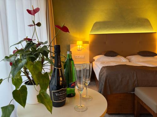 a room with two bottles of wine and glasses on a table at The Golden Wheel Hotel in Prague