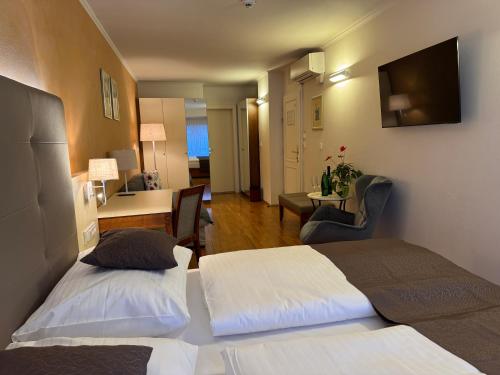 a hotel room with two beds and a desk at The Golden Wheel Hotel in Prague