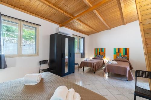a room with two beds and a living room at Fiumara Val Di Noto Country Rooms in Noto