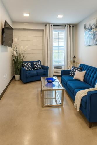 a living room with blue couches and a glass table at The Groovy Blue in Birmingham