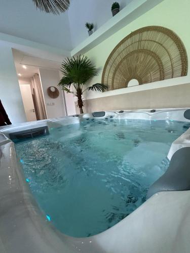 a large bath tub in a room with at Les Volets Bleus house and spa in Jublains