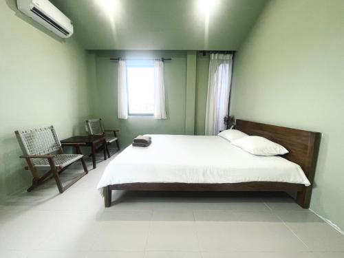 a bedroom with a bed and a window and a chair at Biển house in Ấp Khánh Phước (1)